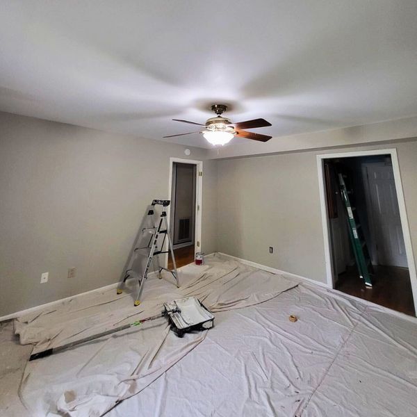 Does My Home Need To Be Empty for Residential Interior Painting Services_-img2 Room being painted, with drop cloths, ladder, and paint tray on the floor.