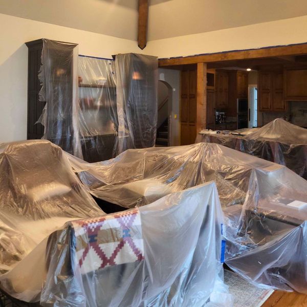 Does My Home Need To Be Empty for Residential Interior Painting Services_-img3 Living room furniture covered in plastic for interior painting.