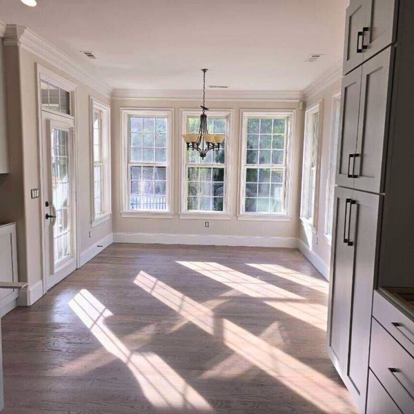 How To Choose The Right Kind Of Interior Paint for Your Home-img2 Sunlit dining room with large windows and light wood floors.