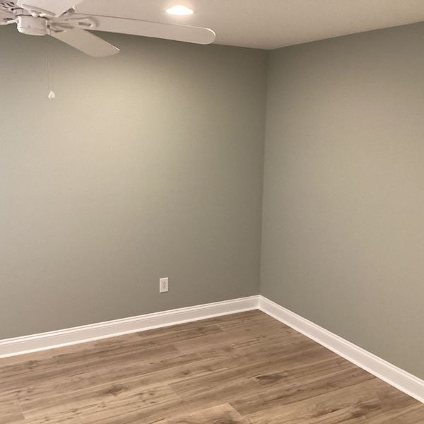 HowCanIKeepPaintFromDryingOut-3 Light gray wall with white trim and wood floor, ceiling fan