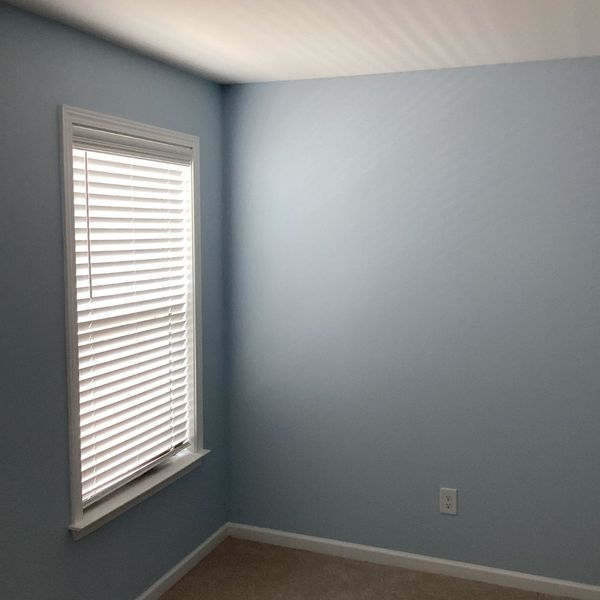 Install New Carpet Before or After Painting_-image2 Light blue room with window blinds and carpet, suitable for painting before carpet installation.