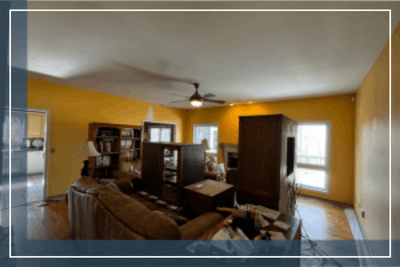 Living room interior with yellow walls, furniture, and windows.