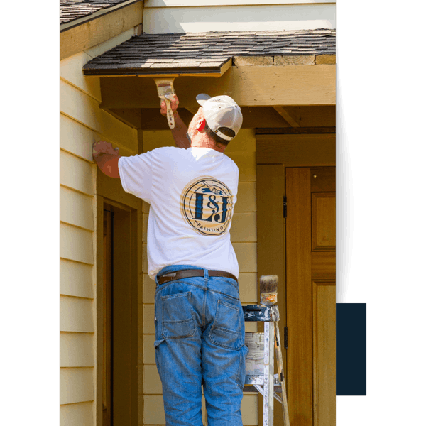 Portfolio 29 Painter in L&J Painting shirt works on exterior house trim.