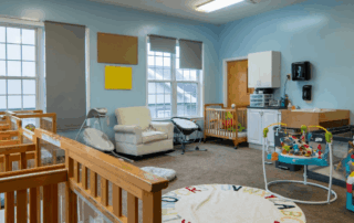 Portfolio 2910 Nursery room with cribs, play mat, and seating area