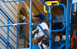 Portfolio 292 Painter in a lift working on house exterior trim