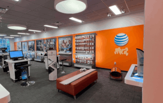 Portfolio 297 AT&T store interior with orange walls, product displays, and seating.