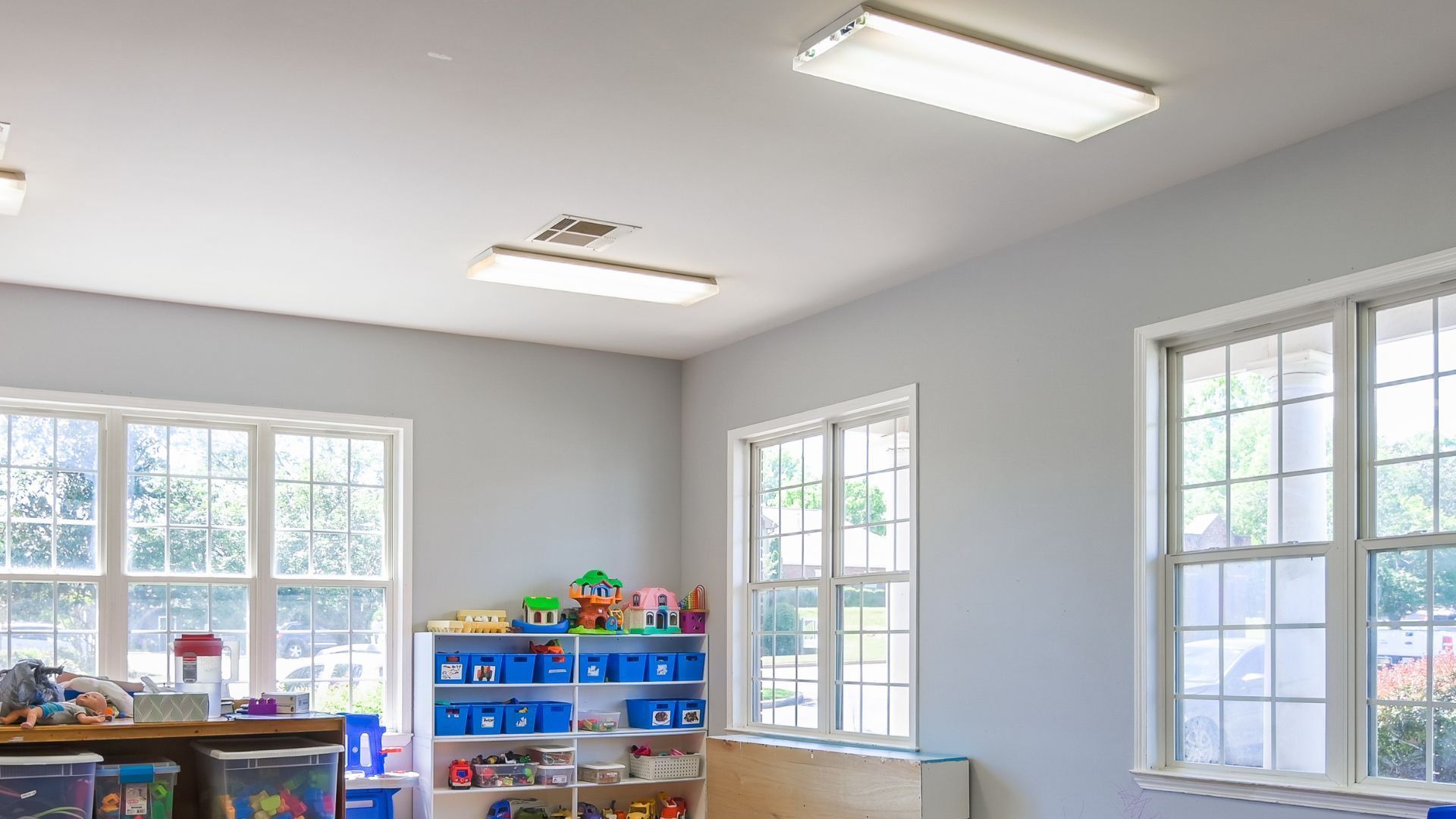 Bright classroom with toys, windows, and overhead lights