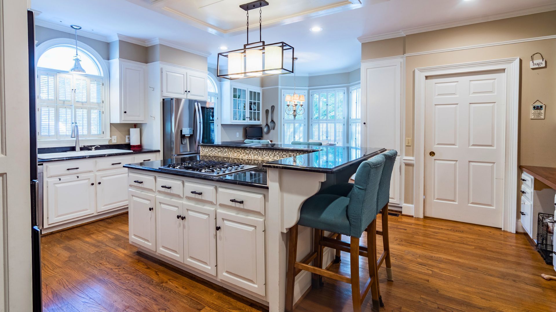 Spacious white kitchen with island and bar stools, ideal for home interior paint.