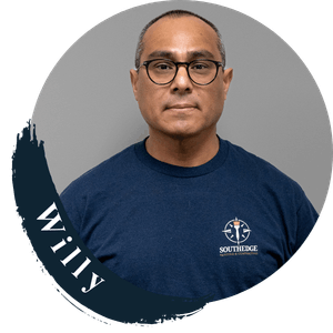 Willy, a man wearing glasses and a navy blue South Edge t-shirt