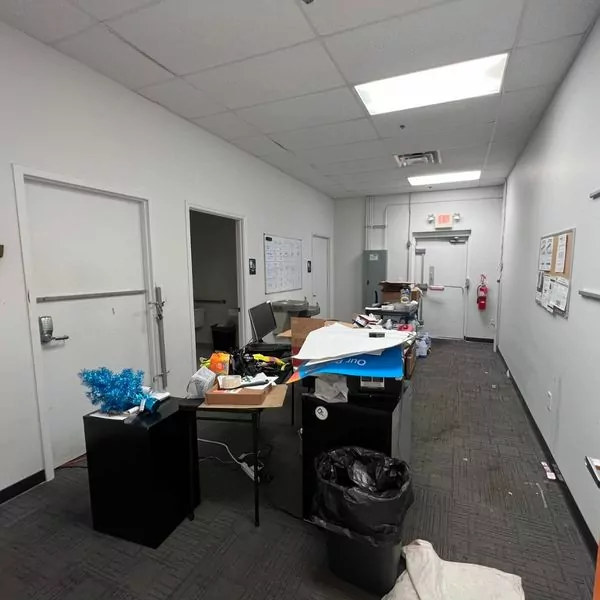 PrepYourOffice 29 Messy office hallway with desks, doors, and trash before commercial painting.